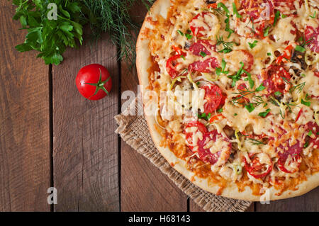 Pizza mit Salami, Tomaten und Pilze. Ansicht von oben Stockfoto