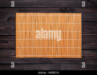 Bambusmatte auf einem Holztisch, Ansicht von oben Stockfoto