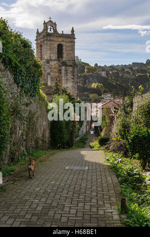 Fußgänger Straße, Bogen von der Wand, Eingang des Dorfes mit der Kirche im Hintergrund in Laredo, Kantabrien, Spanien. Stockfoto