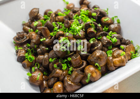 Sautierte frische Crimini Pilze, garniert mit Frühlingszwiebeln garnieren Stockfoto