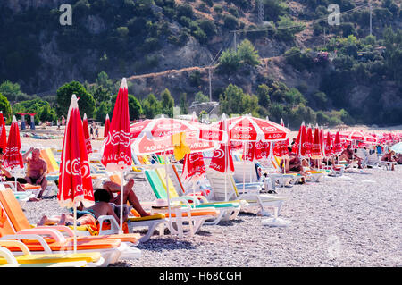 Reihe von Sonnenliegen und Sonnenschirme am Strand in Ölüdeniz, Türkei Stockfoto