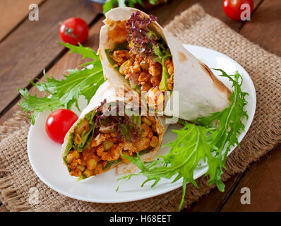 Burritos wraps mit Hackfleisch und Gemüse auf einem hölzernen Hintergrund. Stockfoto
