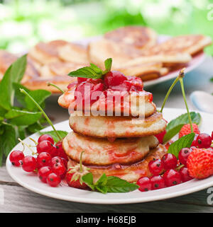 Pfannkuchen mit Beeren auf einem hölzernen Hintergrund im Sommergarten Stockfoto