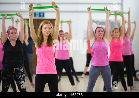 TeilnehmerInnen in Pfund-Fitness-Klasse, einstündigen Training Trommeln steigt Kern Kraft, Surrey, UK Stockfoto