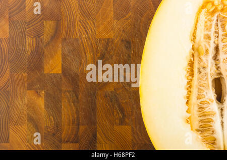 die Hälfte der Reife saftige Melone auf hölzernen Hintergrund Stockfoto