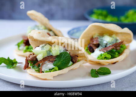 Mini Fladenbrote mit knusprige Lamm, Erbsenpüree, Gurke, Minze und Joghurt-sauce Stockfoto