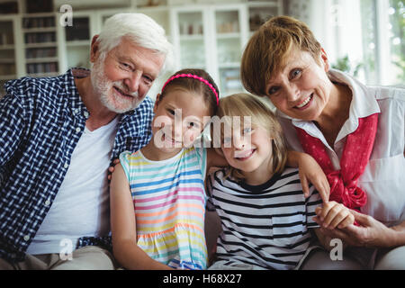 Porträt von Großeltern mit ihren Enkelkindern sitzen Stockfoto