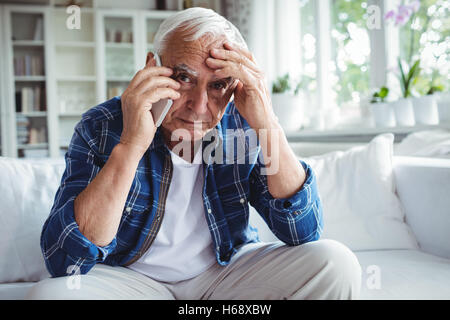 Gespannten senior woman telefonieren mit Handy Stockfoto