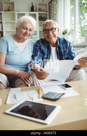 Älteres paar Lächeln während der Überprüfung der Rechnungen Stockfoto
