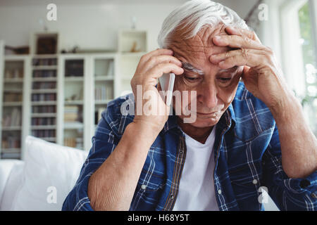 Gespannten senior woman telefonieren mit Handy Stockfoto