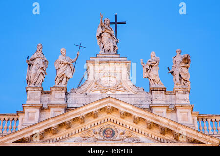 Rom - die Statue auf der Oberseite Fassade des St. John Lateran-Basilika (Basilica di San Giovanni in Laterano) in der Abenddämmerung Stockfoto
