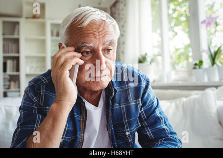 Gespannten senior woman telefonieren mit Handy Stockfoto