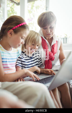 Enkel mit Laptop mit ihrer Großmutter Stockfoto