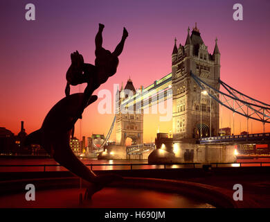 Tower Bridge und Meerjungfrau und Delphin-Statue an der Dämmerung, London, England, UK Stockfoto