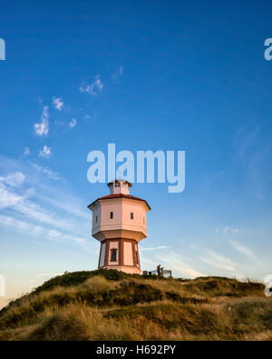 Wasserturm Langeoog. Deutschland Deutschland. Langeoog das Wahrzeichen der Stadt der Wasserturm, Wasserturm, in der Goldenen Stunde kurz nach Sonnenuntergang fotografiert. Die Richtung des Lichts gibt einen großartigen Sinn für die drei Dimensionen der Turm. Das Licht gibt einen wunderbaren goldenen Glanz zu den weißen Wasserturm. Stockfoto