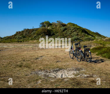 Melkhörndüne, Langeoog. Deutschland Deutschland. Ein paar der traditionellen Stil Fahrräder am Fuß der Dünen geparkt. Es ist eine helle, sonnige Tag mit blauem Himmel. Stockfoto