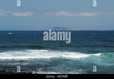 Fuerteventura, Atlantik, Nordafrika, Spanien: Felsen, Wellen und Blick auf Lanzarote von der kleinen Insel Lobos gesehen Stockfoto