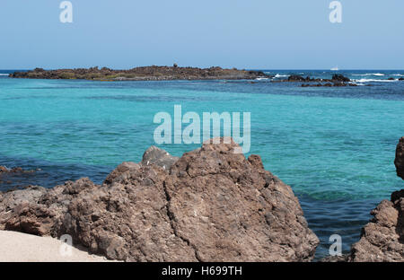 Kanarische Inseln, Nordafrika, Spanien: das kristallklare Wasser und die schwarzen Felsen auf der kleinen Insel Lobos, 2 km nördlich von Fuerteventura Stockfoto