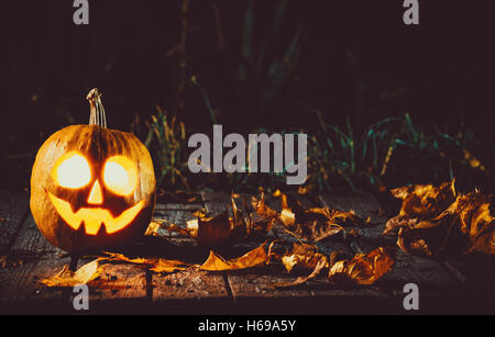 Glühenden Kürbis symbolisiert den Kopf, die des alten Jack, mit Herbst Nacht in einem gespenstisch dunklen Hintergrund verlässt. Soft-Fokus. flachen DOF Stockfoto