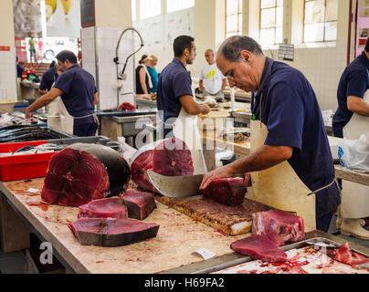 Ein Fischhändler schneidet Scheiben Thunfisch mit einer Machete Messer in der Markthalle von Funchal auf der portugiesischen Insel Madeira Stockfoto