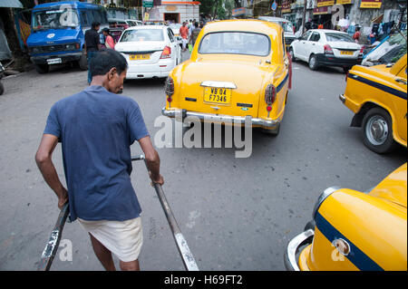 Öffentliche Verkehrsmittel Hand zog Rikscha und gelbes Taxi in der Nähe von Kali Tempel in West Bengal Kolkata Indien. Stockfoto