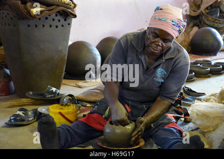 Eine Frau zeigt, wie schafft sie die Tontöpfen zum Verkauf bei Mukondeni Töpferei in der Limpopo-Region in Südafrika. Stockfoto