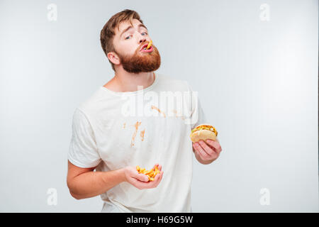 Glücklicher bärtigen Mann genießen Essen Hamburger isoliert auf weißem Hintergrund Stockfoto