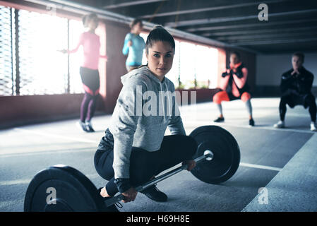 Fit gesunde Frau übt, sitzen am Stock mit Blick in die Kamera, immer bereit, Gewicht heben Stockfoto