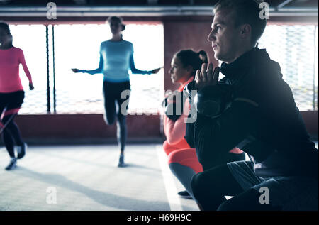Gruppe von Menschen, die Fitness-Übung mit Gewichten trainieren und das Überspringen von Seilen Stockfoto