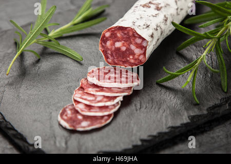 Salami auf dunklem Hintergrund Stockfoto