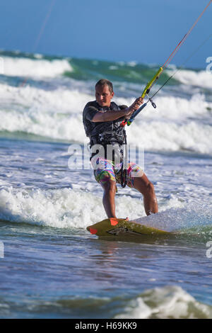 Sportlicher Mann springen auf Kite Surfbrett auf den Wellen des Meeres Stockfoto