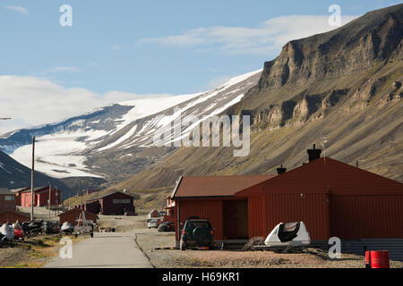 Europa, Norwegen, Svalbard (Spitzbergen), Longyearbyen, Hauptstraße mit typischen Gebäuden und Snow capped Berge hinter Stockfoto