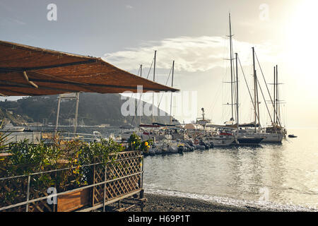 Lipari, Äolischen Inseln/Italien – 16. September 2016. Ansicht eines Restaurants in Lipari nahe dem Meer, Boot im Hintergrund. Stockfoto