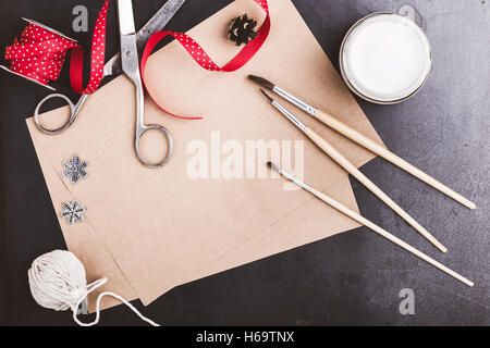 Leeres Papier Handwerk, Farben und Pinsel auf blaue Tabelle mit textfreiraum zur Begrüßung Text von oben betrachtet, Weihnachtsferien Stockfoto