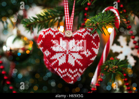 Weihnachten Deko Herz auf Xmas Tree und Garland Hintergrund gestrickt Stockfoto