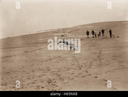 1903-Maschine starten planmäßig am Big Kill Devil Hill vor der 14. Dezember-Testversion. Vier Männer aus Kill Devil Hills lebensrettende Station half auf den Hügel, begleitet von zwei kleinen Jungen und ein Hund aus dem Schuppen zu bewegen. Stockfoto