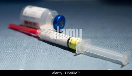 Eine Spritze mit Anästhesie Beruhigungsmittel, Propofol, (das Michael-Jackson-Medikament), und ein leeres Glas-Fläschchen auf ein blaues Tuch Stockfoto