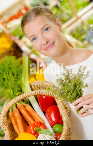 Lady, die Zugabe von Kräutern, Einkäufe in einem Korb Stockfoto