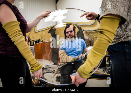 Spezialist für Glasbläser James Devereux inspiziert eine halb fertige Stück Glas nach Glas Rondelle für eine Skulptur in seiner Werkstatt in Wiltshire darzulegen. Stockfoto