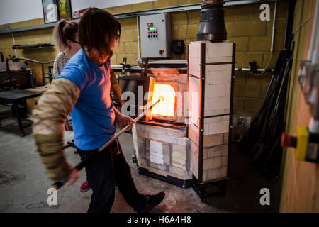 Er macht deutlich, Glas Rondelle für eine Skulptur in seiner Werkstatt in Wiltshire sammelt Spezialist Glasbläser James Devereux Glasschmelze aus einem Ofen. Stockfoto