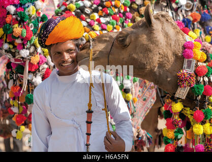 Kamel und seine unbekannten Besitzer kümmert sich beim traditionellen Kamel Dekoration Wettbewerb Kamel Mela in Pushkar, Rajasthan, Indien Stockfoto