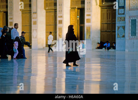 Besucher der Umayyad Moschee in Damaskus zu Fuß über den glitzernden Marmor des Hofes. Auf dem 21.08.2001 gefangen genommen. Die Umayyaden-Moschee in Damaskus ist eine der ältesten der Welt. Es wurde im Stil einer alten Basilika erbaut und in vorislamischer Zeit war die Kathedrale, wo Johannes der Täufer gewidmet war. Traditionelle Aufzeichnungen, zufolge wird seinen Kopf in einem Schrein beibehalten. Die Moschee enthält einen umfangreiche Hof mit drei kleineren Nebengebäuden; Das Uhr-Haus, das Brunnen-Haus und dem berühmten Säulen Treasury, wo der Legende nach Stand Schätze früher gespeichert wurden. Phot Stockfoto