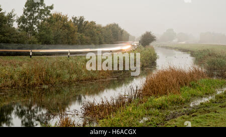 Willingham, Cambridgeshire, Großbritannien, 26. Oktober 2016. Autofahrer stellen eine trübe pendeln im Venn in Richtung Cambridge am Fluss unterwegs entlang der Old West River. Der Morgen begann mit Nebel und Nebel im Herbst. Kredit Julian Eales/Alamy Live-Nachrichten Stockfoto