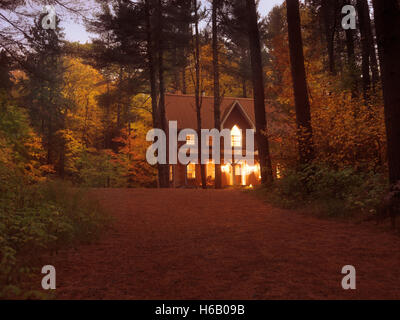 Ziegel-Landhaus oder Ferienhaus mit Licht in bunten Herbstabend Twilight Naturkulisse in Muskoka, Ontario, Kanada cou Stockfoto