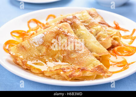 Pfannkuchen mit orange Sirup auf weißen Teller Stockfoto