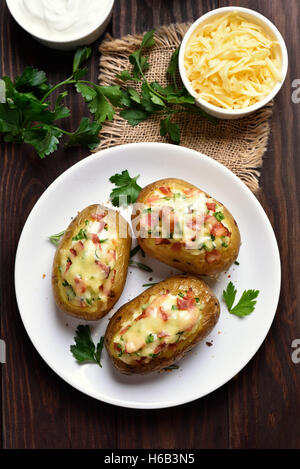 Hausgemachte Kartoffelschalen mit Speck, Käse und grüne Zwiebel, Ansicht von oben Stockfoto