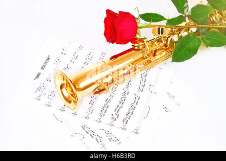 Rote Rose, Saxophon und Musik Blatt auf weißem Hintergrund Stockfoto