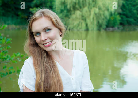 Porträt einer Frau mit langen Haaren am See Stockfoto