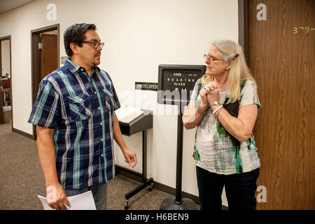 Hispanic und kaukasischen Administratoren von einem Santa Ana, CA, Community College Nachhilfe Zentrum verleihen außerhalb eines Klassenzimmers. Beachten Sie die Zeichen für das Lesen von Klasse. Stockfoto