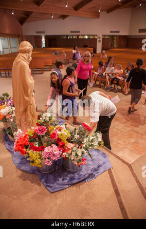 Eine Prozession von Kindern legen Sie Blumen neben einer Statue der Jungfrau Maria während der Zeremonie der Krönung Mariens am St. Timothy katholische Kirche, Laguna Niguel, CA. Das Ereignis bezieht sich auf spezielle Marienandachten gehalten in der katholischen Kirche während der m Stockfoto